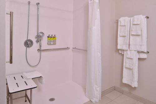 a white bathroom with a shower and a shower curtain at Holiday Inn Express & Suites - Olathe West by IHG in Olathe