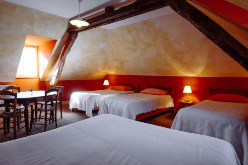 a hotel room with two beds and a table and chairs at Le Poujastou in Juzet-de-Luchon