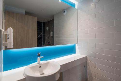 a bathroom with a sink and a mirror at Holiday Inn Express - Paris - CDG Airport, an IHG Hotel in Roissy-en-France