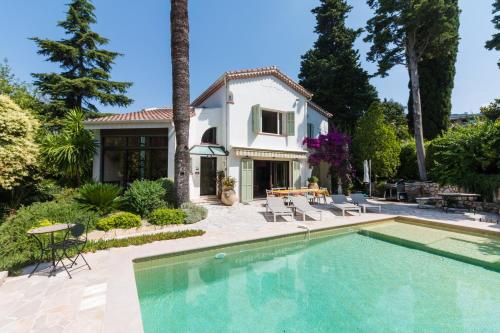 a house with a swimming pool in front of a house at Villa Tsavorite - Cannes Californie in Cannes