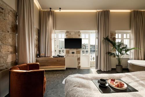 a hotel room with a bed with a tray of food on it at Divino Suites Chania in Chania