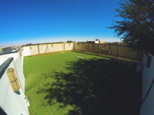 an image of a yard with a fence at Rey Lagarto Hostel in San Pedro de Atacama
