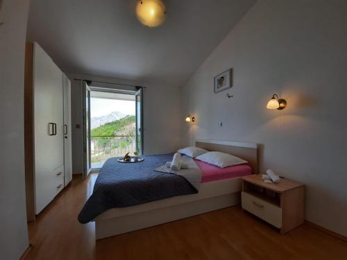 sypialnia z dużym łóżkiem i dużym oknem w obiekcie Villa Tilda w Breli
