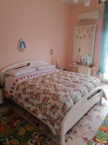 a bedroom with a bed with a floral bedspread at Appartamento Nelli in Reggio di Calabria