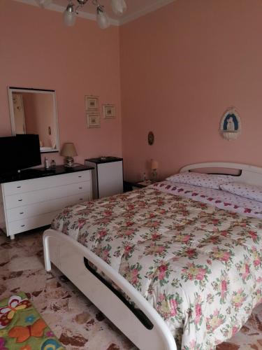 a bedroom with a bed and a dresser and a television at Appartamento Nelli in Reggio di Calabria