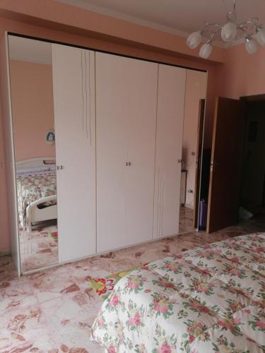 a bedroom with white cabinets and a bed at Appartamento Nelli in Reggio di Calabria