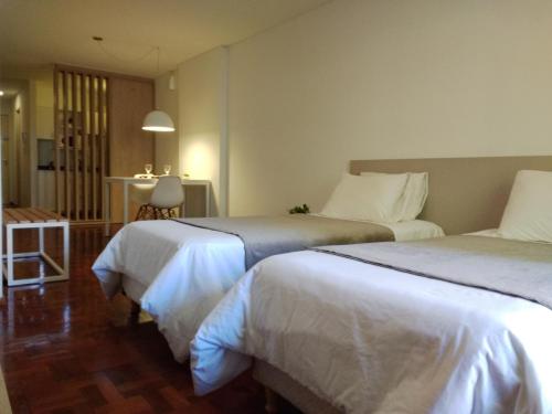 a hotel room with two beds and a table at Departamentos Lugar in Cordoba