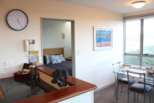 a room with a bed and a clock on the wall at The Anchorage Apartments in Mount Maunganui