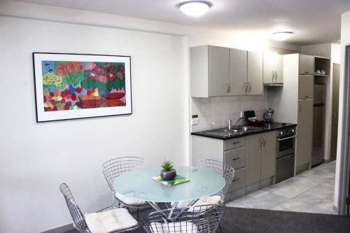 a kitchen with a table and chairs in a room at The Anchorage Apartments in Mount Maunganui