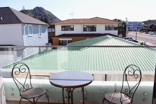 a table and chairs on a balcony with a roof at The Anchorage Apartments in Mount Maunganui