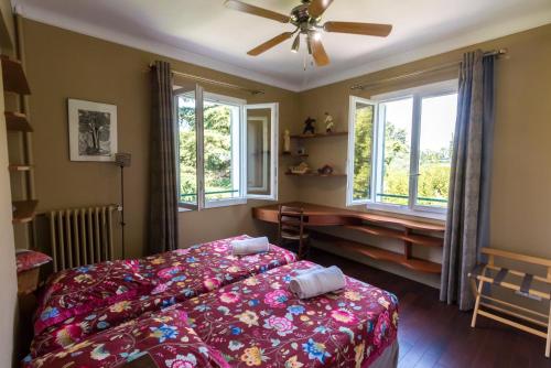 - une chambre avec un lit, un ventilateur et des fenêtres dans l'établissement Villa Tsavorite - Cannes Californie, à Cannes