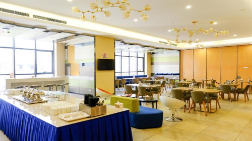 una sala da pranzo con tavoli e sedie in un edificio di Holiday Inn Express Zhangjiakou Park View, an IHG Hotel a Zhangjiakou