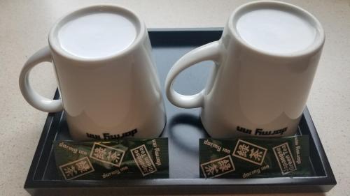 two coffee mugs on a tray on a table at Dormy Inn Hiroshima in Hiroshima