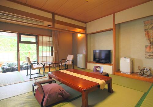 a living room with a table and a tv at Nasu Hoshi no Akari in Nasu