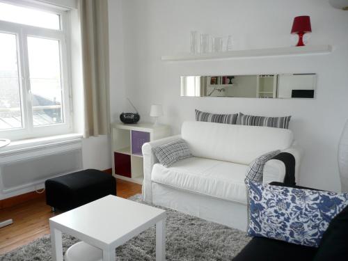 een woonkamer met een witte bank en een tafel bij LE CHARME WIMEREUSIEN - lumineux - tout à pied in Wimereux