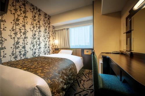 A bed or beds in a room at APA Hotel Hitachinaka Katsuta Station