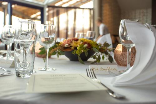 a table with wine glasses and flowers on it at Bø Hotel in Bø
