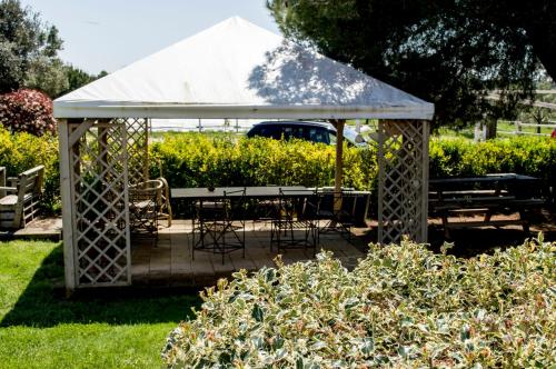a gazebo with a table and chairs in a garden at Villa Enli in Capalbio