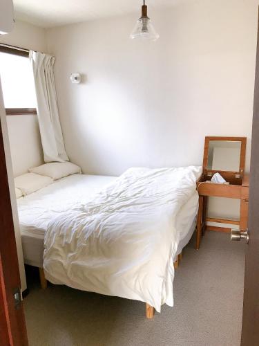 a small bedroom with a bed and a chair at Children's cafe B&B Kimie in Kamakura