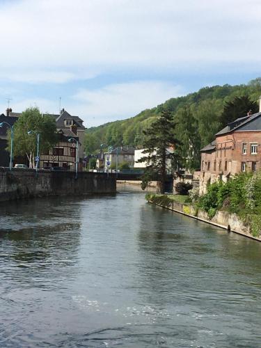 a river in a town with houses and buildings at Chambre Chez L'HABITANT en Centre Ville in Pont-Audemer