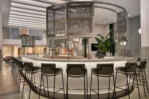 a bar in a hotel lobby with a bunch of stools at Hotel Indigo - Williamsburg - Brooklyn by IHG in Brooklyn