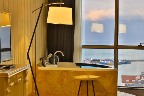 a kitchen with a sink and a large window at Ramada By Wyndham Iskenderun in İskenderun