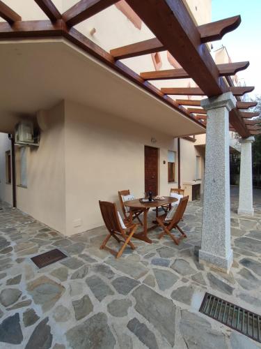 an outdoor patio with a wooden table and chairs at Apartment Stella Maris in Cala Gonone