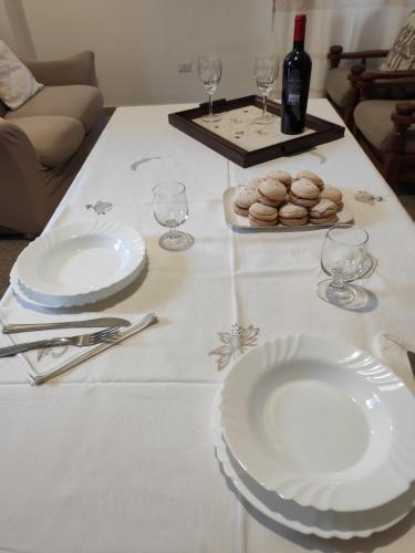 a table with white plates and wine glasses on it at Apartment Stella Maris in Cala Gonone