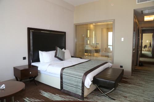 a hotel room with a large bed and a table at Ramada By Wyndham Iskenderun in İskenderun