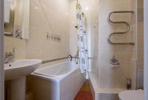 y baño con bañera, lavamanos y ducha. en Zolotoye Runo, en Novosibirsk