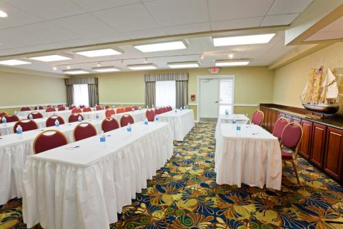 a conference room with white tables and red chairs at Holiday Inn Express Hotel & Suites Port Clinton-Catawba Island by IHG in Port Clinton