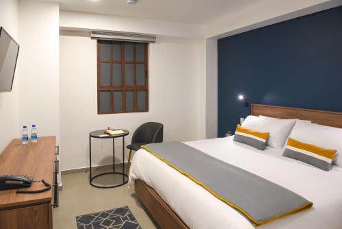 um quarto de hotel com uma cama grande e uma secretária em Hotel Boutique Parque Centro em Cidade do México