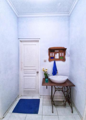 a bathroom with a sink and a white door at Rumah Sorai in Batu