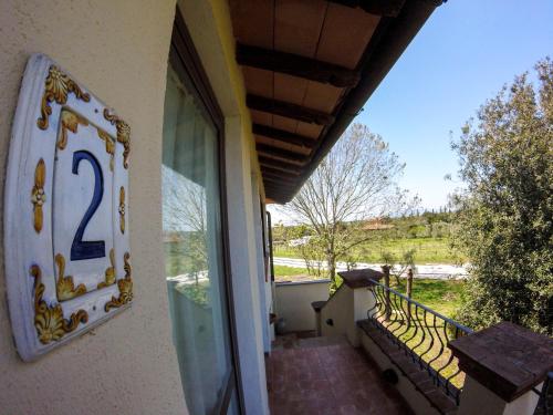a sign on the side of a building next to a balcony at Villa Enli in Capalbio