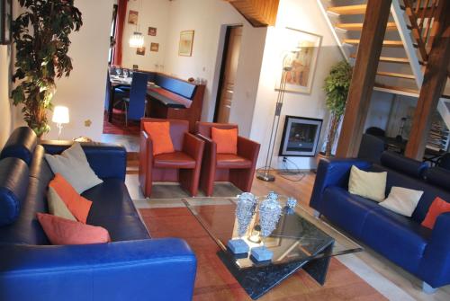 a living room with blue couches and orange chairs at Holiday House Arnultovice in Rudník