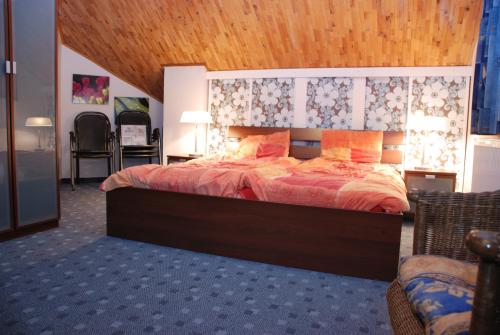 1 dormitorio con 1 cama grande y techo de madera en Holiday House Arnultovice, en Rudník