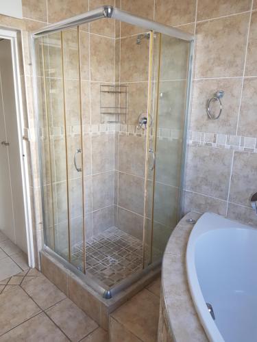 y baño con ducha, aseo y lavamanos. en Bramber Court Art-Deco Self-Catering Apartments en Ciudad del Cabo