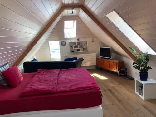 a bedroom with a large red bed in a attic at La Maison des Copains in Blonay