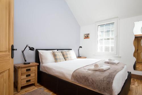 a bedroom with a bed and a window at Castle Vista, Grassmarket Apartment in Edinburgh