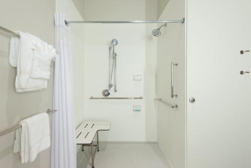 a white bathroom with a shower and a bench at Holiday Inn Express Troy, an IHG Hotel in Troy