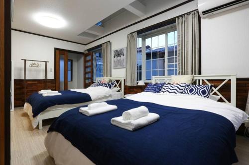 a bedroom with two beds with towels on them at アンドステイ石川町 in Yokohama