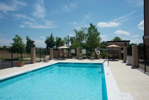 a pool at a resort with tables and chairs at Holiday Inn Express Hotel & Suites Prattville South, an IHG Hotel in Prattville