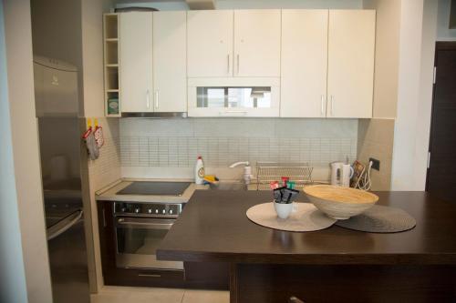 a kitchen with white cabinets and a wooden bowl on a counter at Ahoy Luxury Apartment in Belgrade