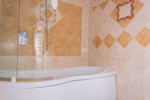 um banheiro com chuveiro, vaso sanitário e banheira em Hôtel & Spa La Villa em Sainte-Maxime