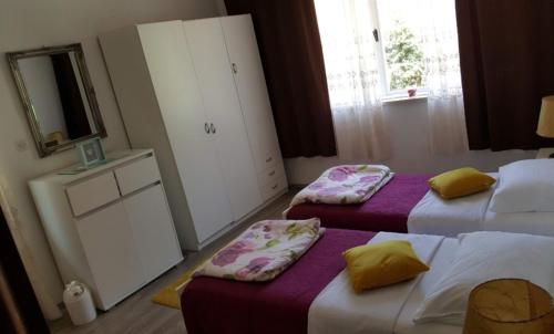a hotel room with two beds and a mirror at Barko apartment and rooms in Hvar