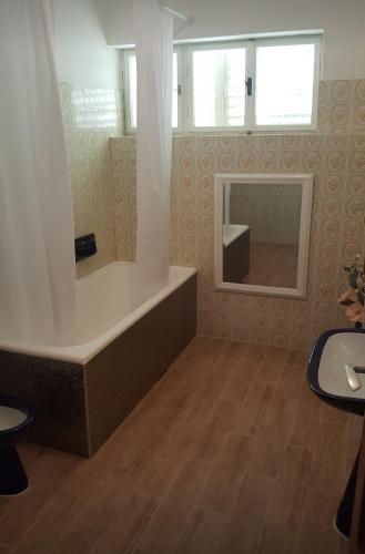 a bathroom with a tub and a mirror at Barko apartment and rooms in Hvar