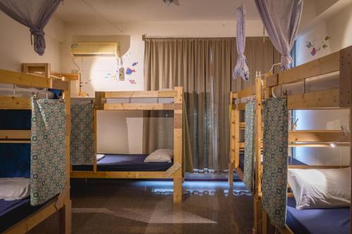 a room with four bunk beds in a house at Fish Hostel in Yingge