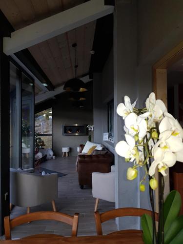 a living room with a couch and white flowers at Gîte Chalet du Soulor in Arrens-Marsous