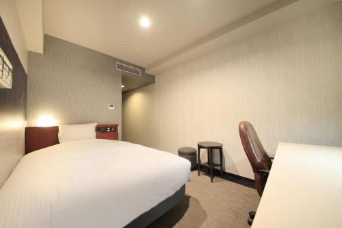 a hotel room with two beds and a chair at Richmond Hotel Tokyo Musashino in Musashino
