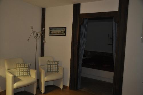 a living room with two chairs and a mirror at Chesa Viletta in La Punt-Chamues-ch